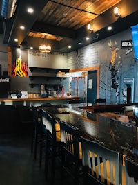 the interior of a restaurant with televisions and a bar