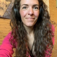 a woman with long curly hair wearing headphones